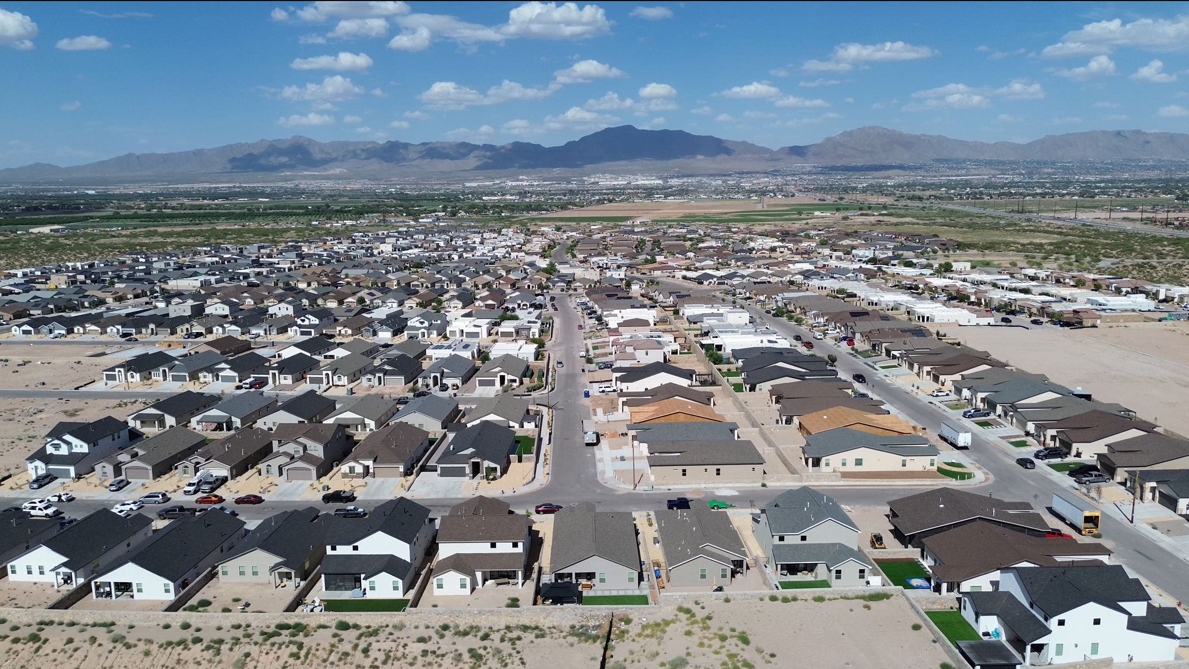 Aerial view of new construction homes in Santa Teresa, New Mexico with mountains beyond