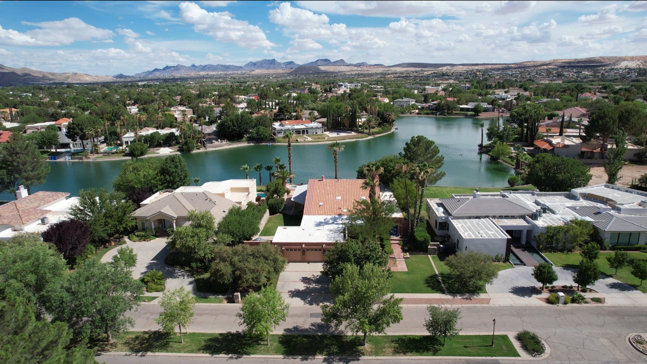 Aerial view of lakeside homes with mature trees in a West El Paso community