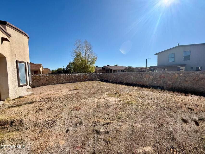 Spacious backyard with stone wall borders and open potential for future customization.