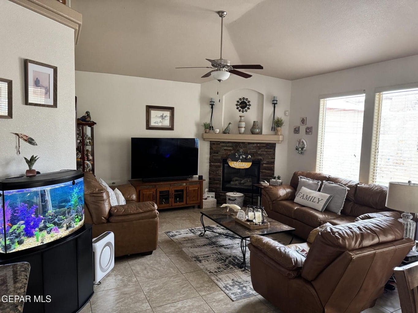 family room with ceiling fan and fireplace