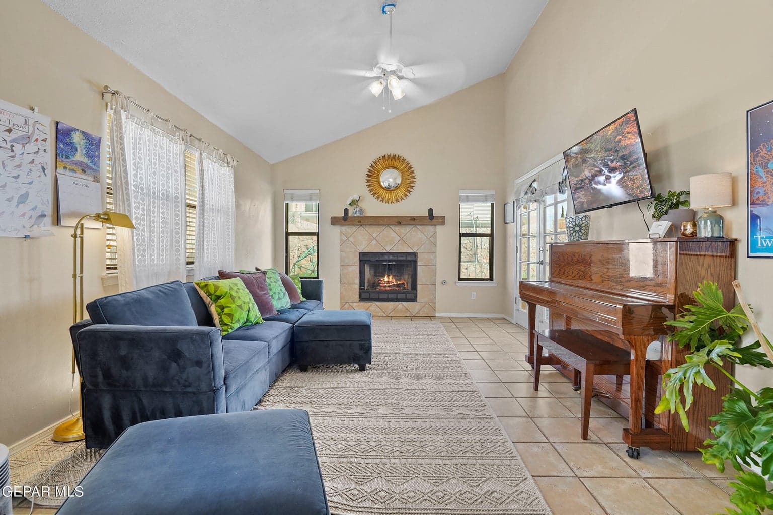 Spacious great room featuring a cozy fireplace and vaulted ceiling.