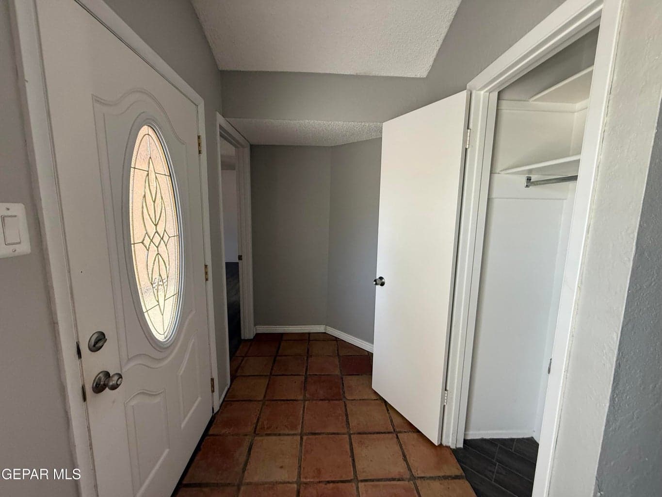 Tiled entrance, coat closet, primary bedroom to left, great room to right.