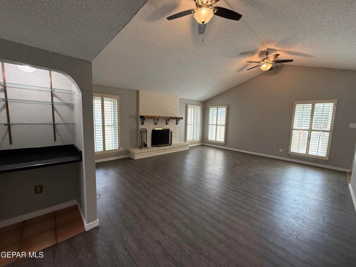 Front wooden shuttered windows with view to front patio and street view. Laminated wood flooring. Tile flooring in bar area. Wood burning fireplace.