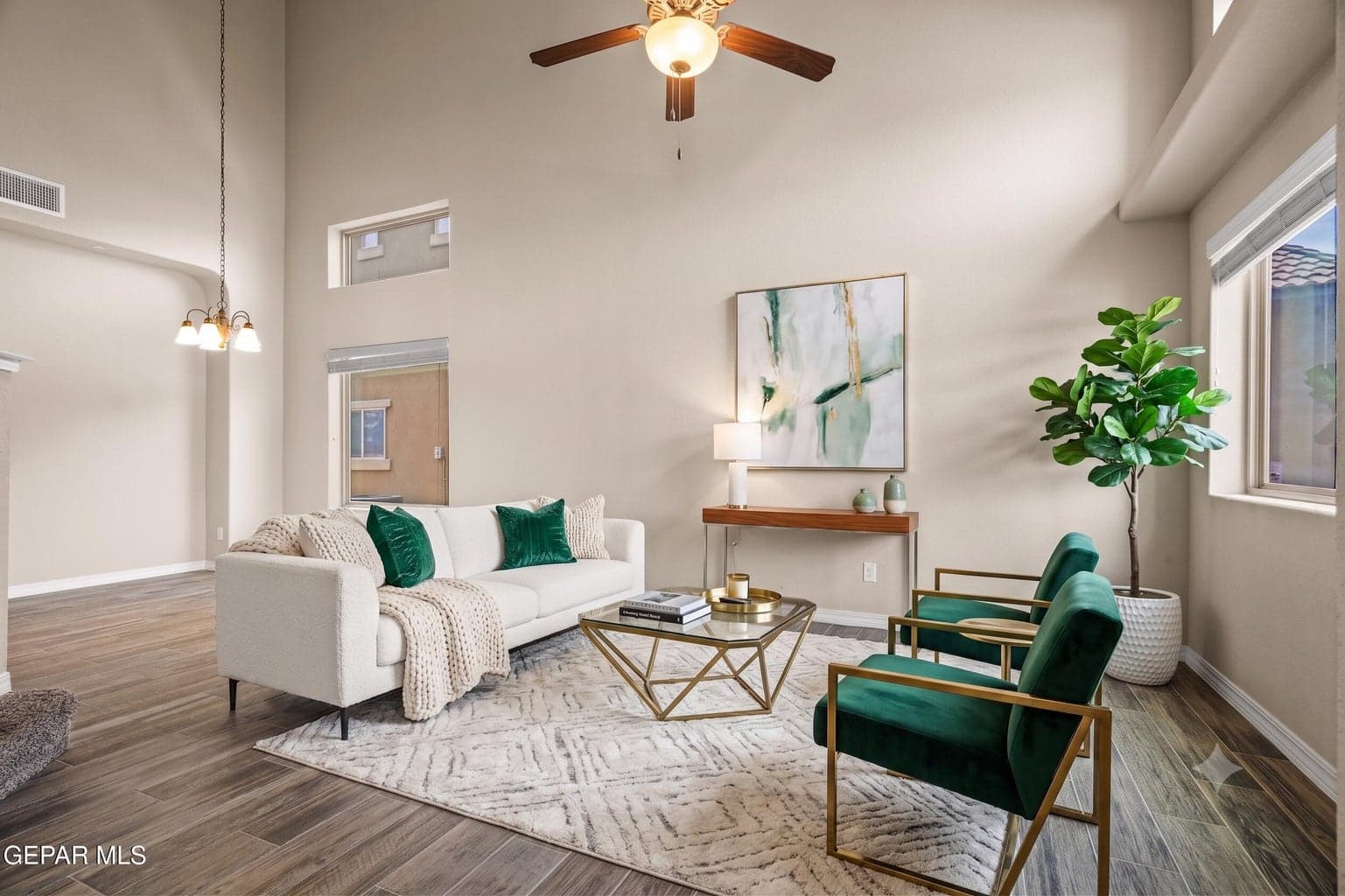 The formal living room features high ceilings and a ceiling fan