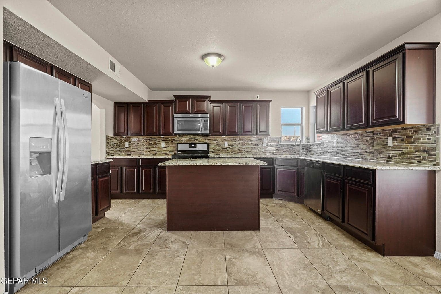The kitchen offers granite countertops, ample cabinetry, and a large island