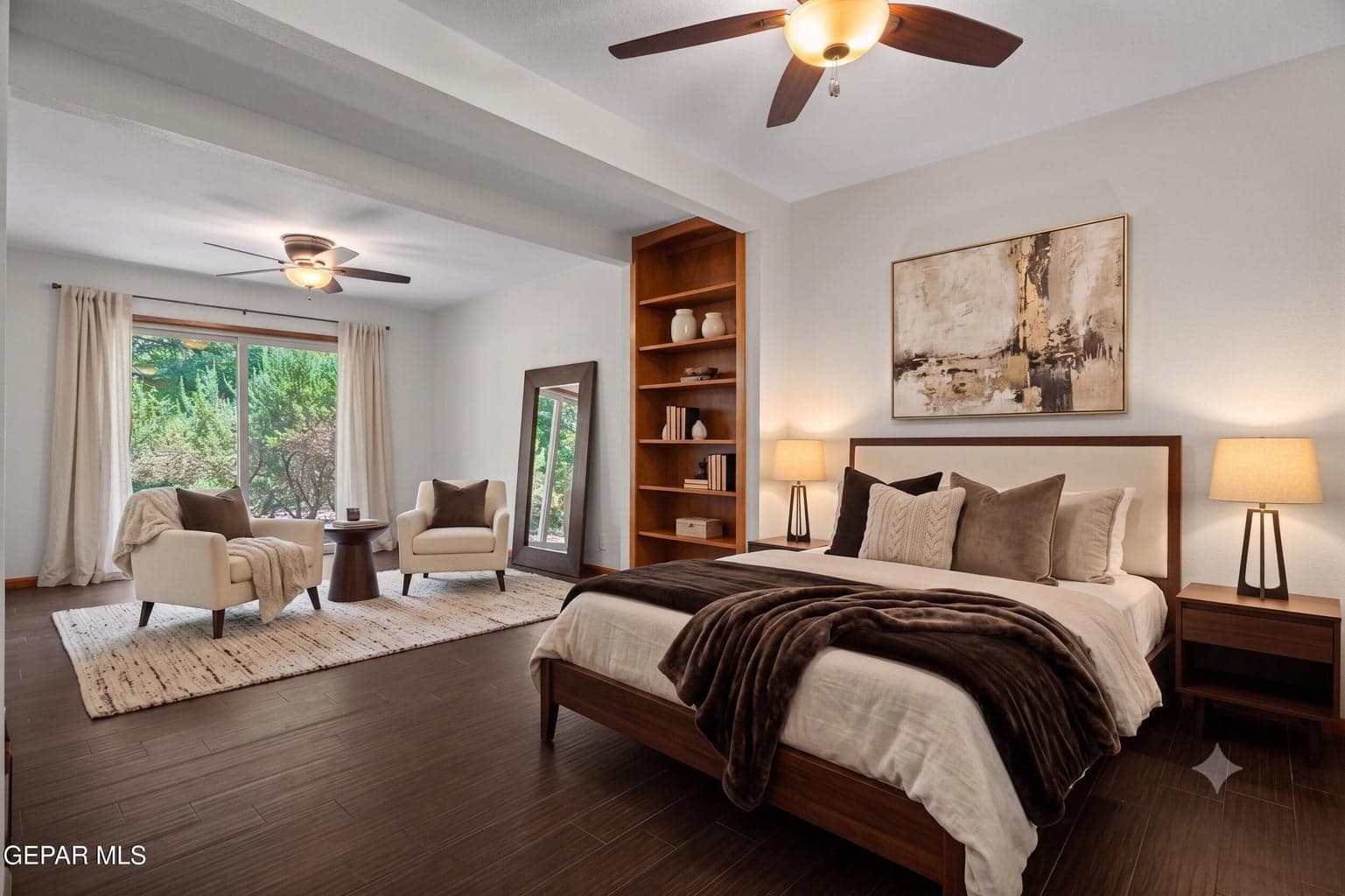 The spacious primary suite offers laminate flooring, a ceiling fan and backyard access