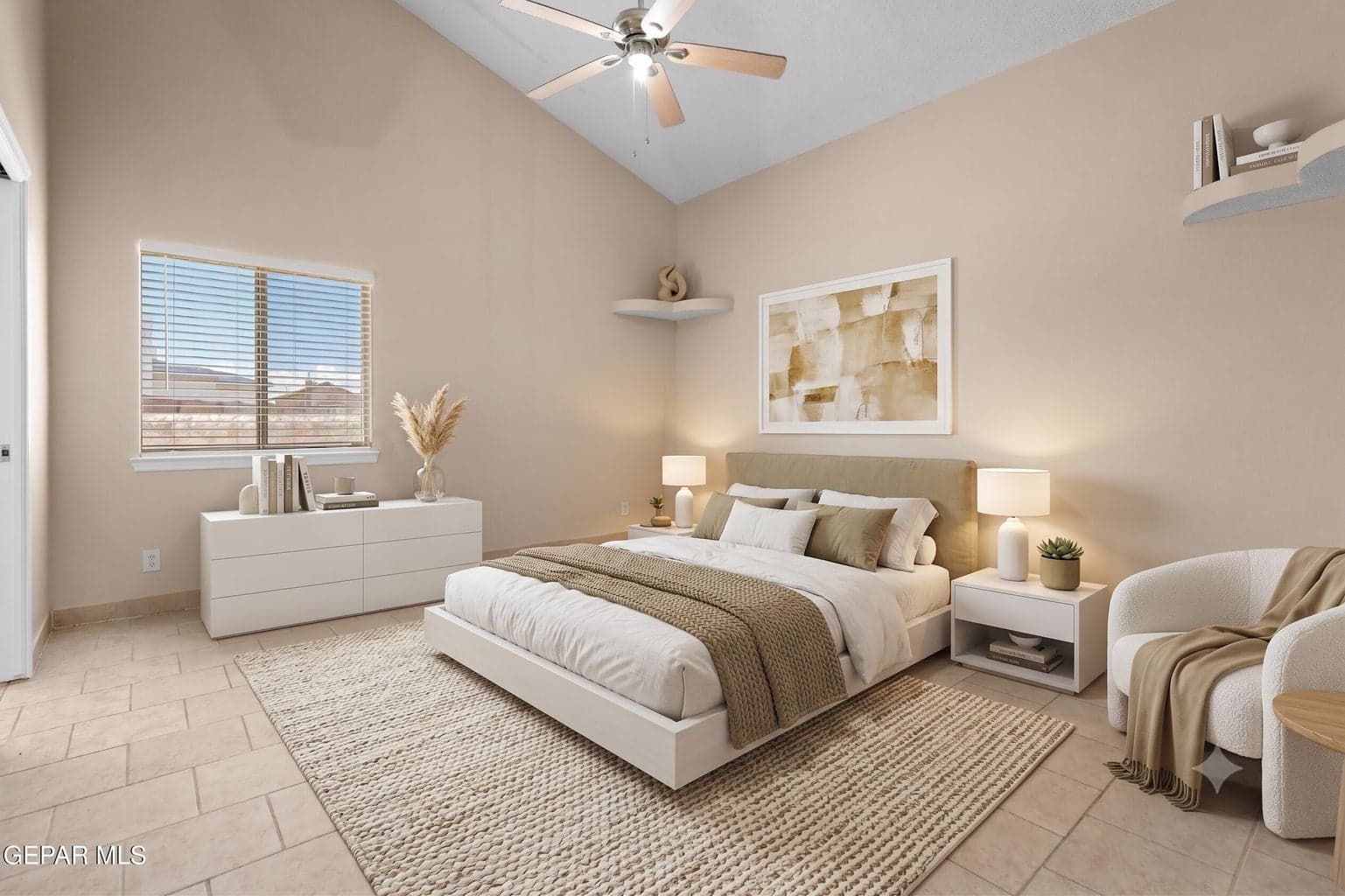 The primary suite offers tile flooring, vaulted ceilings and a ceiling fan