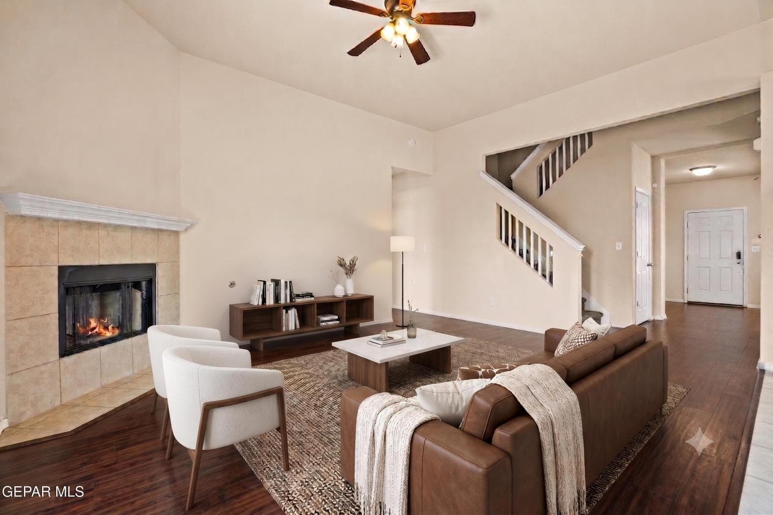 Features a cozy fireplace, and a ceiling fan