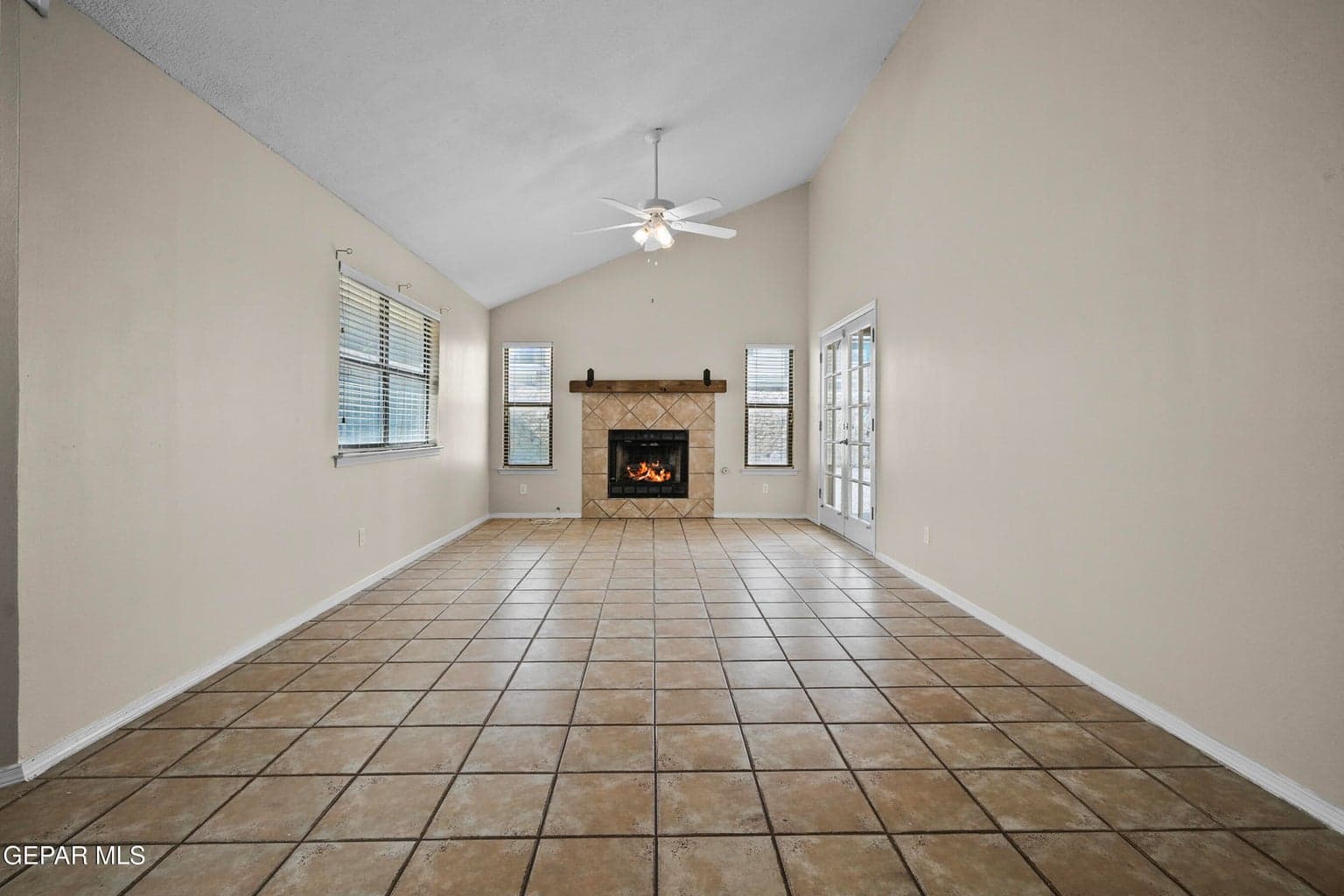 Spacious great room featuring a cozy fireplace and vaulted ceiling.