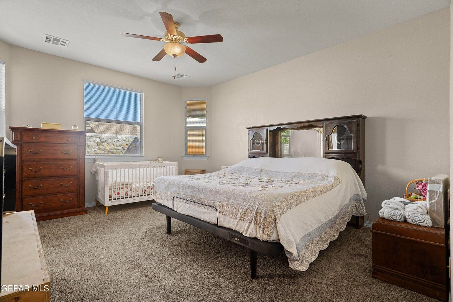 Features carpet flooring, a ceiling fan, and private access to the primary bathroom.