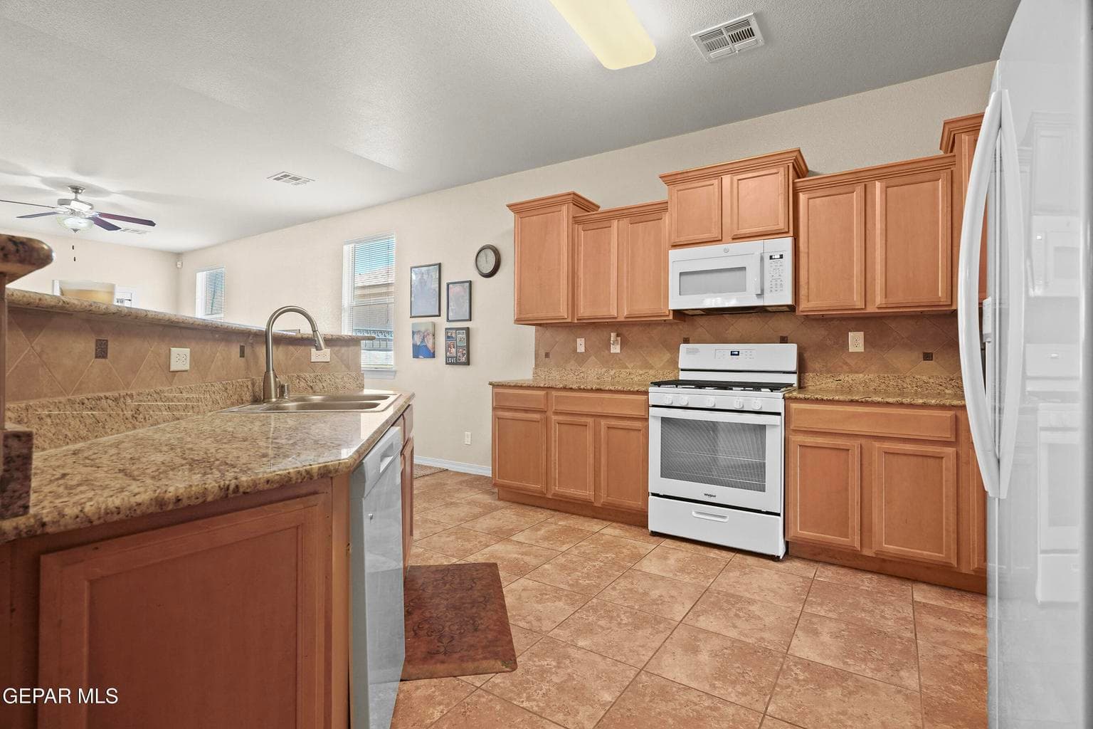 Granite countertops, ample cabinetry and tile flooring