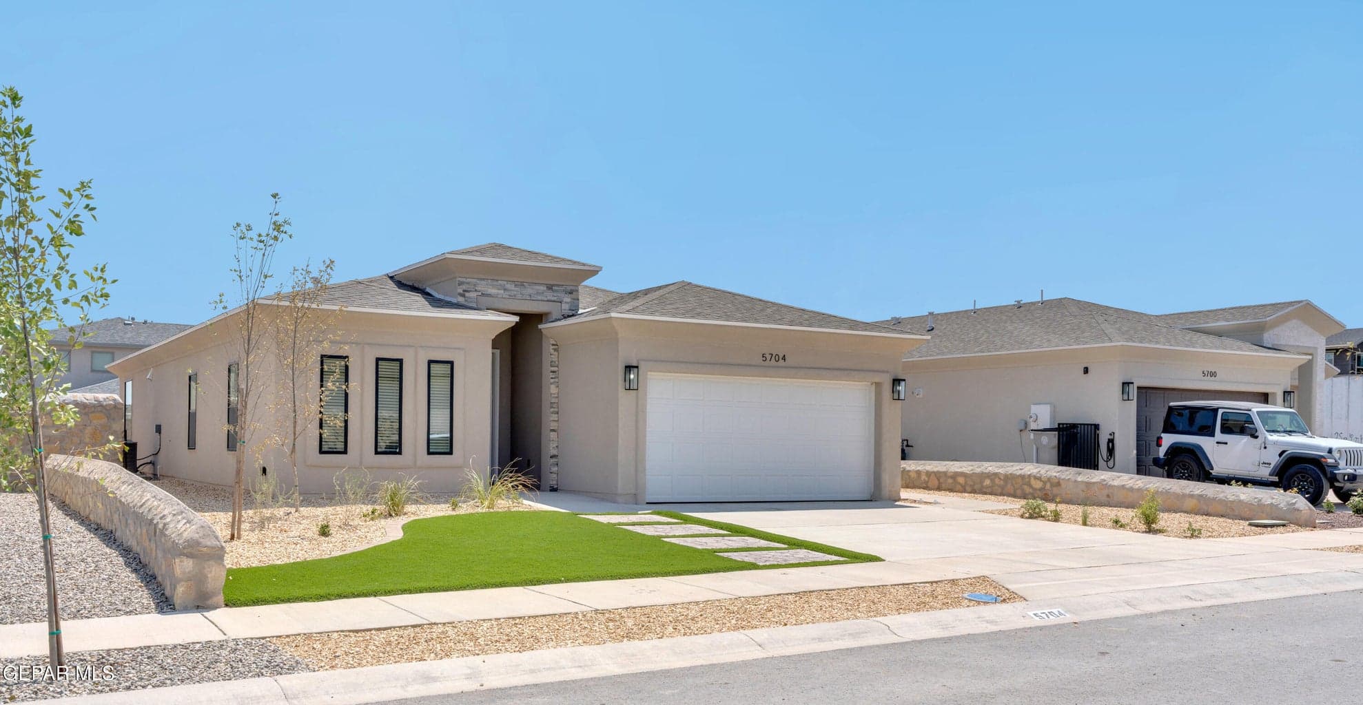 Stucco exterior with stone accents and a sloped roofline