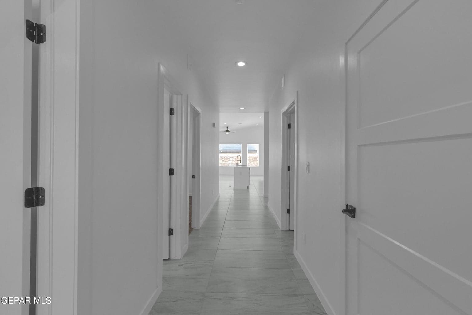 Hallway featuring recessed lighting, tile flooring, and white panel doors