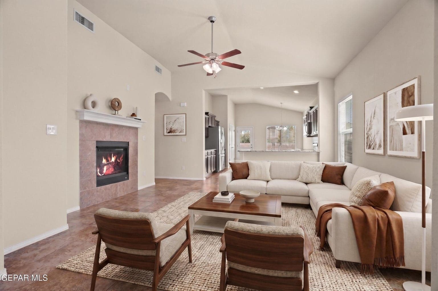 Spacious great room features a fireplace, high ceilings and tile flooring