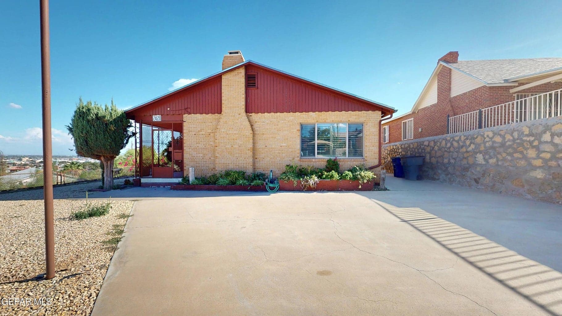 Home sits on a raised lot with a view of the city.