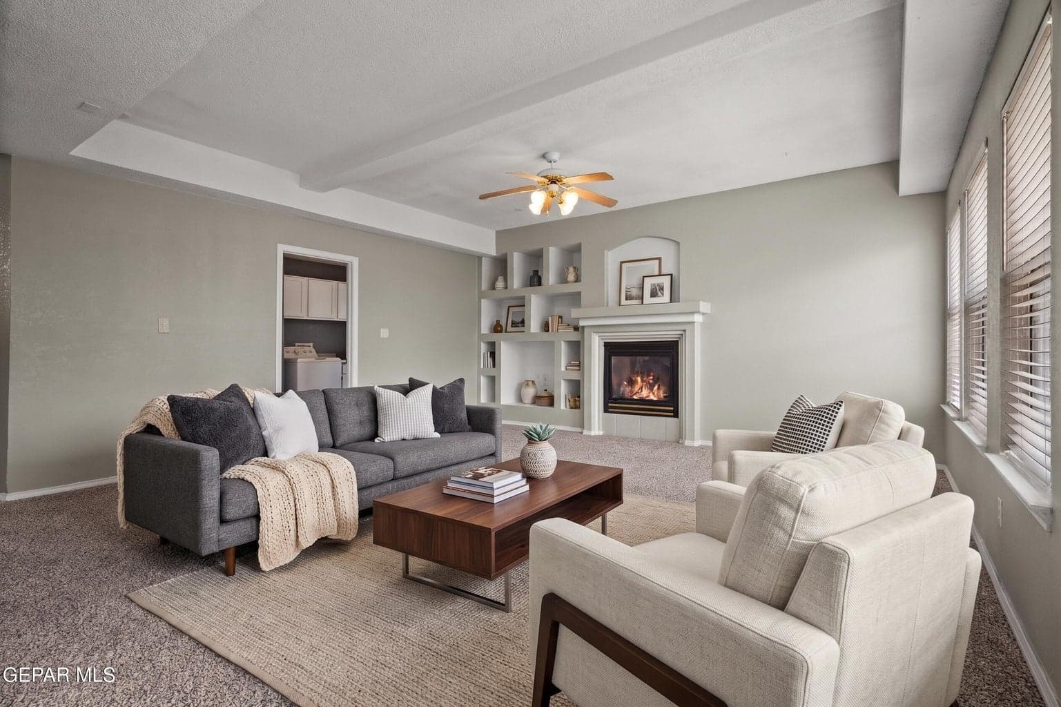 Carpet flooring, a cozy fireplace, and backyard access