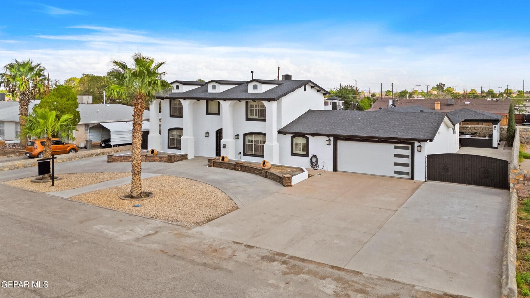 Stucco exterior with black trim, concrete driveway, and attached two-car garage