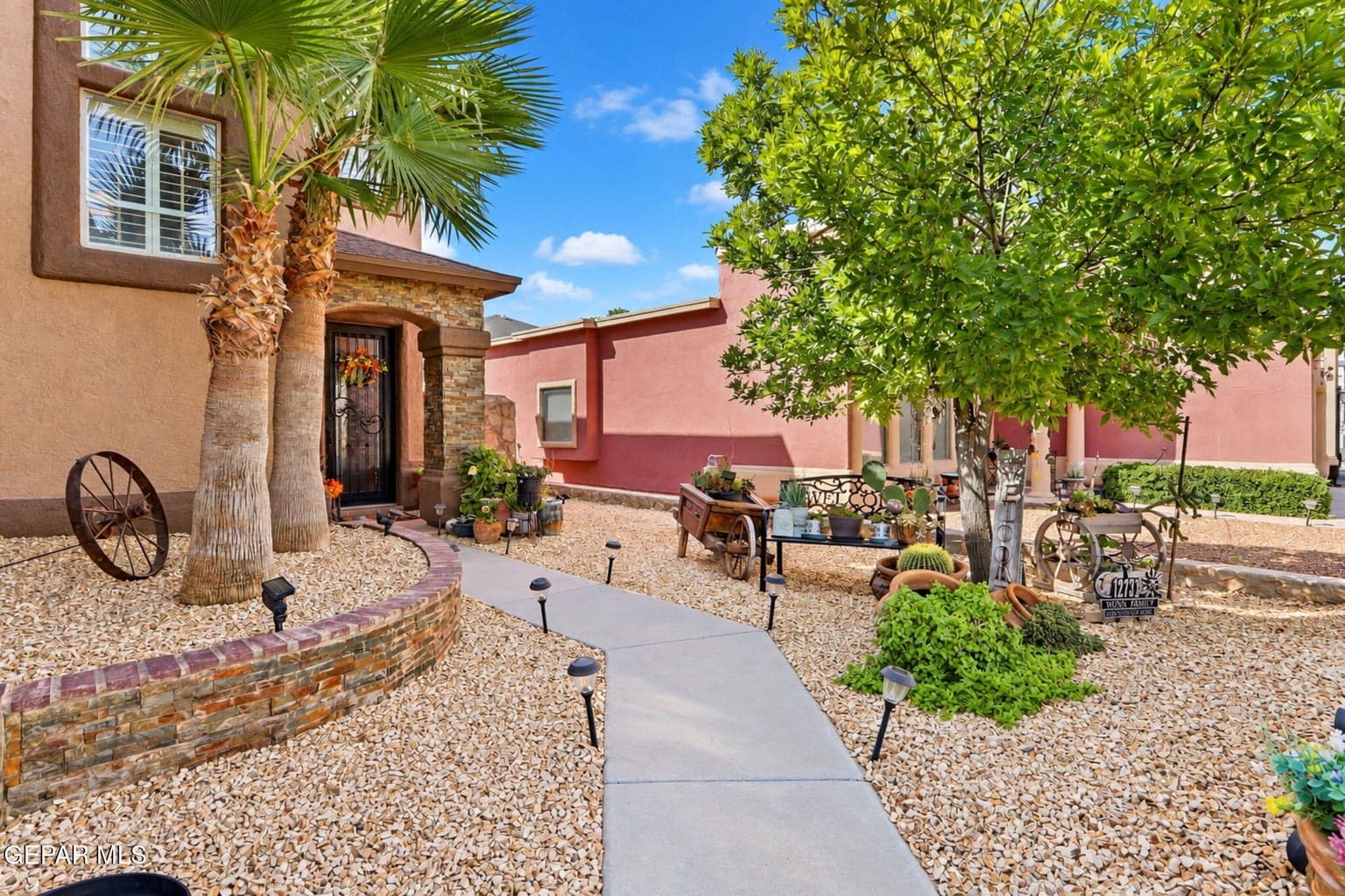 Beautiful curb appeal with mature palm trees and tree