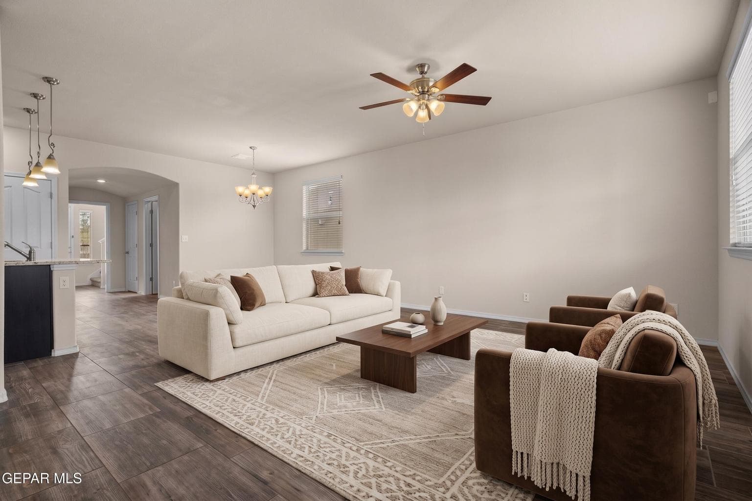 Open great room features tile flooring and ceiling fan