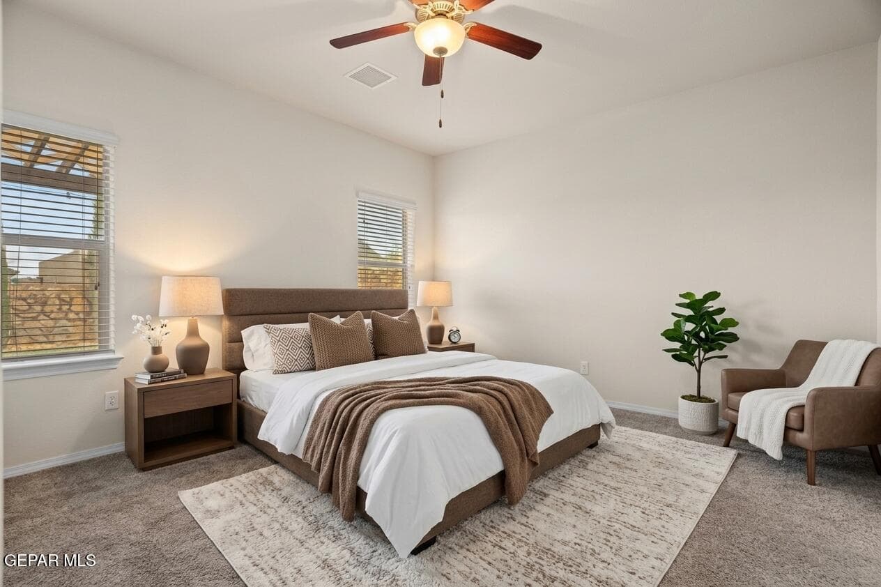 Features carpet flooring, a ceiling fan, and private access to the bath and closet.