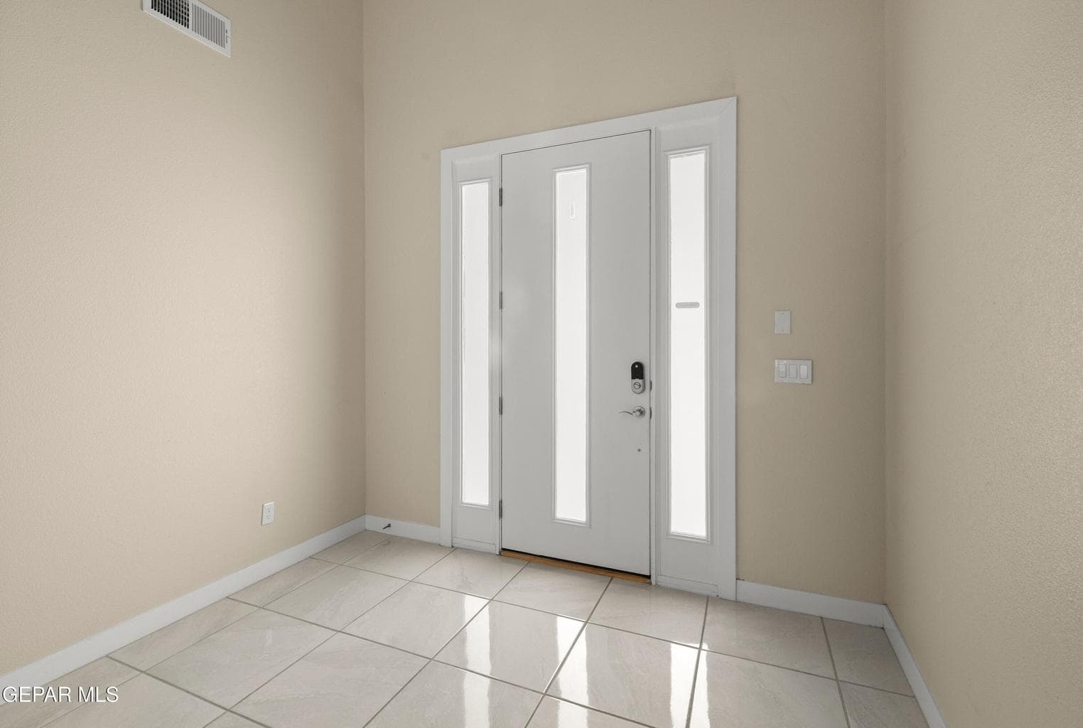 White modern entry with sidelights framing the front entry and high ceilings.