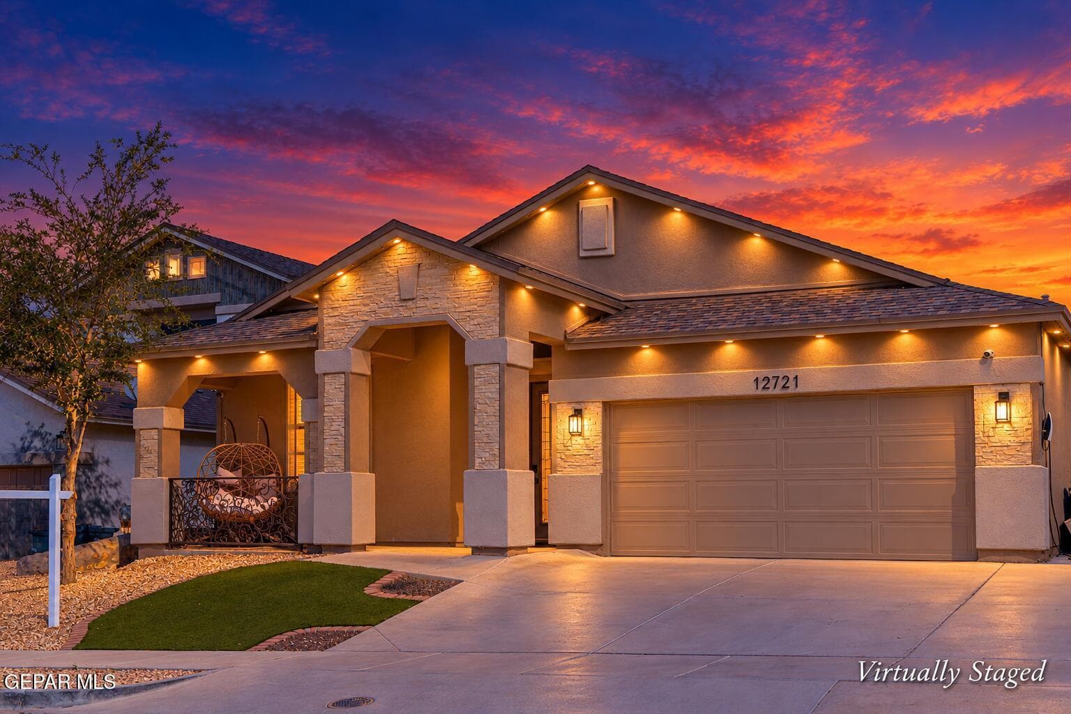 Stucco exterior with stone accents, covered entry, attached garage, concrete driveway, and low-maintenance landscaping