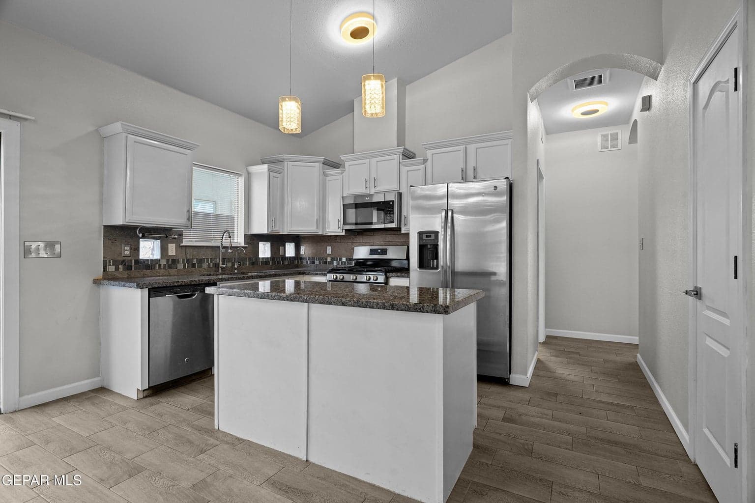 Featuring a kitchen island, ample cabinetry and tile flooring