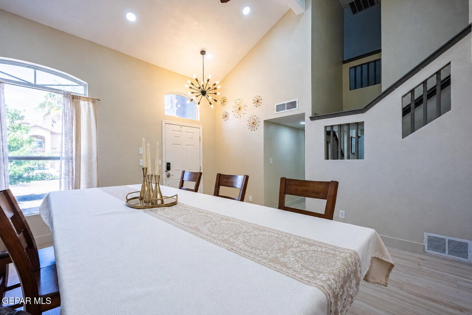 Vaulted ceiling with recessed lighting and a sputnik-style chandelier
