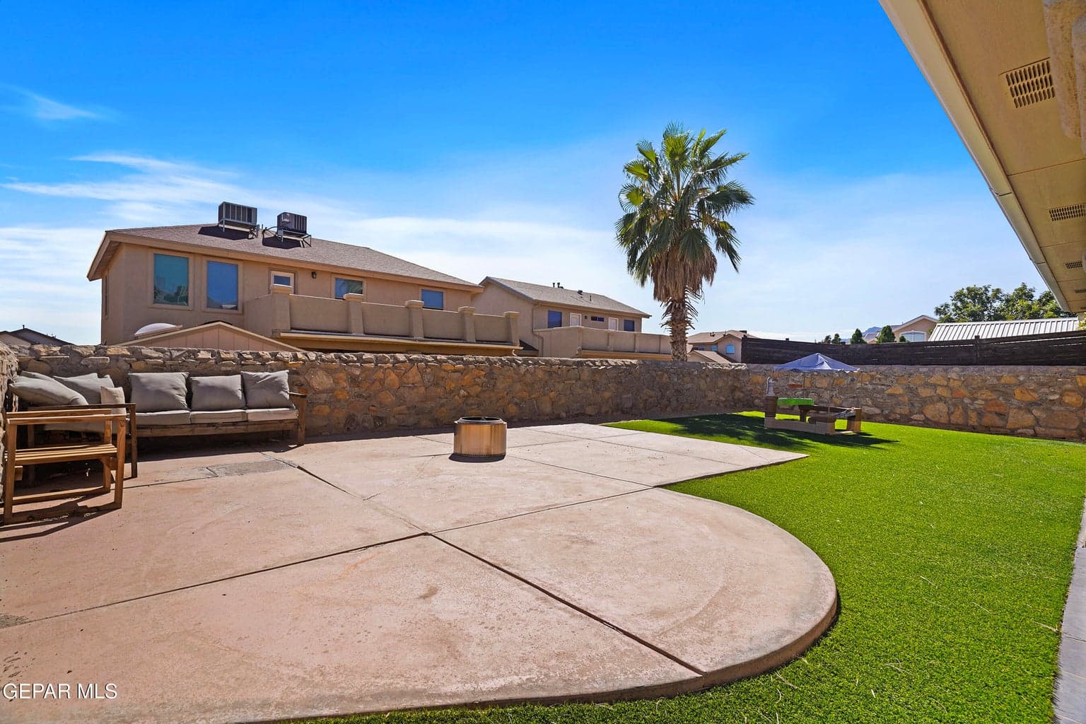 Enjoy a generously sized backyard featuring beautiful landscaping, large concrete patio, artificial turf, and a surrounding wall for added privacy.