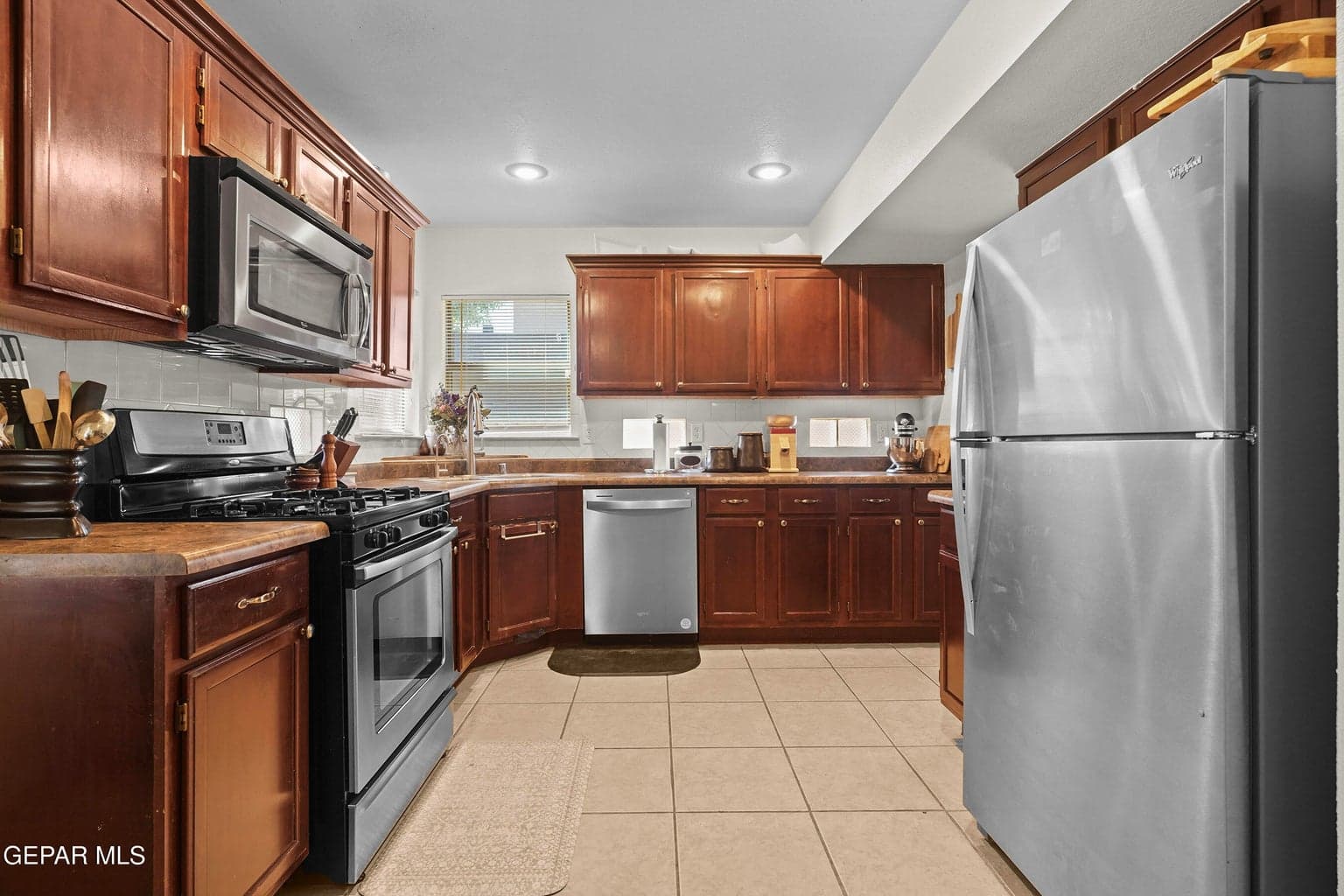 Features stainless steel appliances, tile flooring, and ample cabinetry for storage.