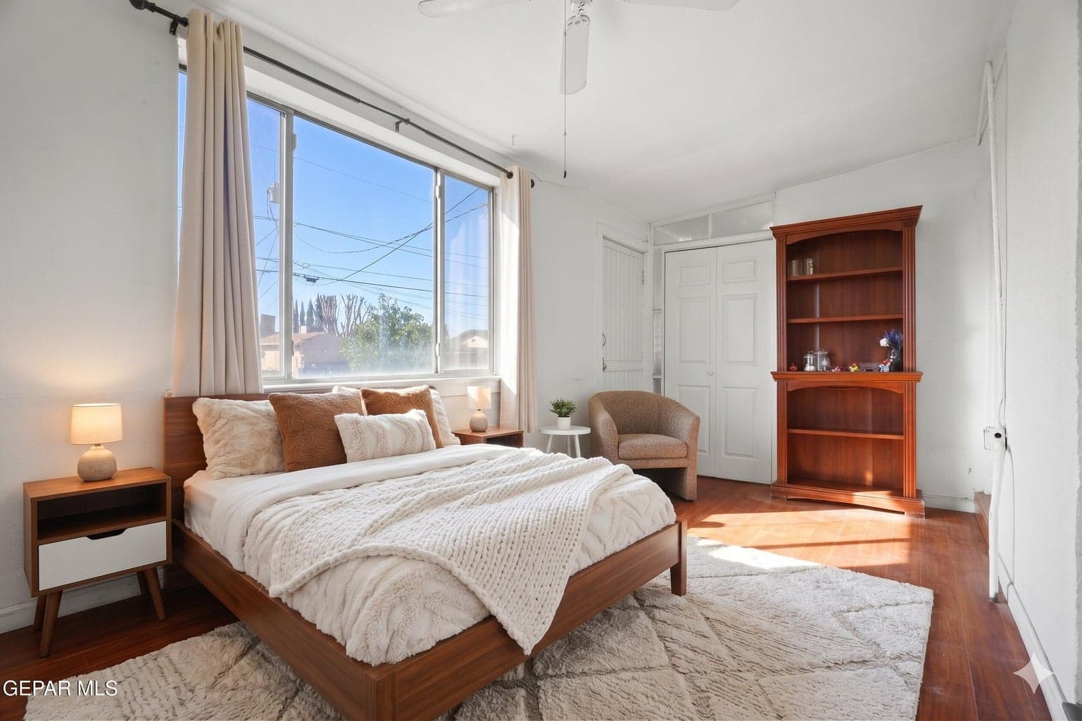 Features wood flooring and a ceiling fan.